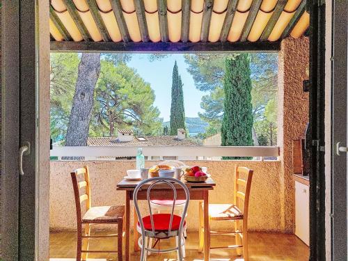 une salle à manger avec une table et des chaises et une fenêtre dans l'établissement Studio Les Hauts du Port-1 by Interhome, à Saint-Cyr-sur-Mer