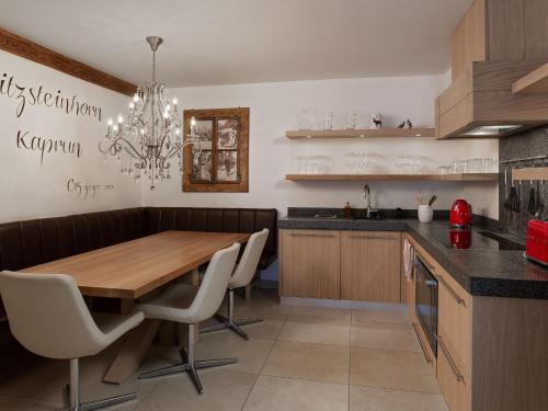 a kitchen with a wooden table and white chairs at Apartment Mountain Resort C15 by Interhome in Kaprun