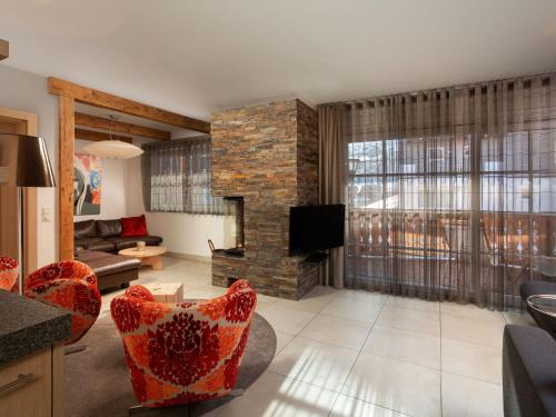 a living room with a couch and a fireplace at Apartment Mountain Resort C15 by Interhome in Kaprun