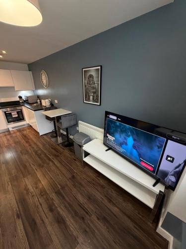 a living room with a large flat screen tv at Stunning City View Studio Apartment by StaySavvy Accommodation in Liverpool