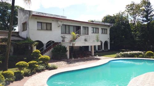 ein Haus mit einem Swimmingpool davor in der Unterkunft Alfords Villa 