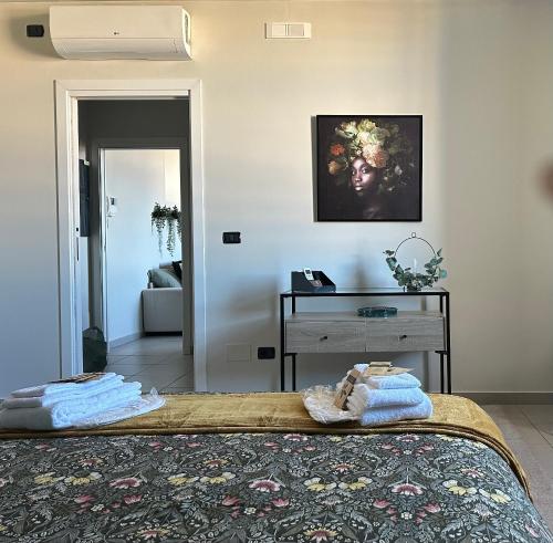 una camera da letto con un letto con un tavolo e una foto appesa al muro di BOTANICAL SUITE a Bari