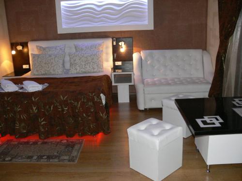 a bedroom with a bed and a couch and a chair at ApartHotel Dom in Odesa
