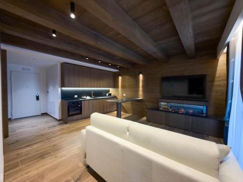 ein Wohnzimmer mit einem weißen Sofa und einem Fernseher in der Unterkunft Luxury Mountain Suites in Roccaraso