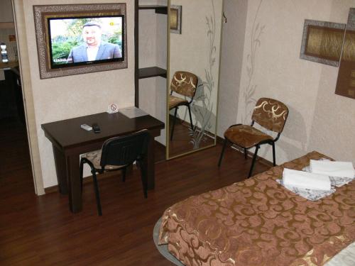 a hotel room with a bed and a tv on the wall at ApartHotel Dom in Odesa