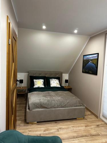 een slaapkamer met een bed in een kamer bij Dom "Między jeziorami" na Kaszubach, 10 osób, jacuzzi, ognisko, kominek in Grabówko