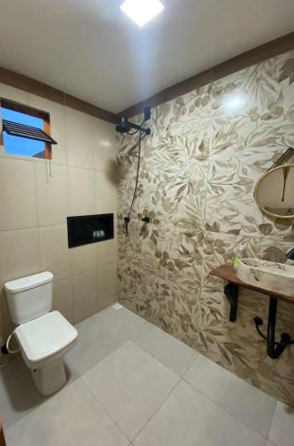 a bathroom with a toilet and a sink at Recanto do Ofurô in Ilhéus