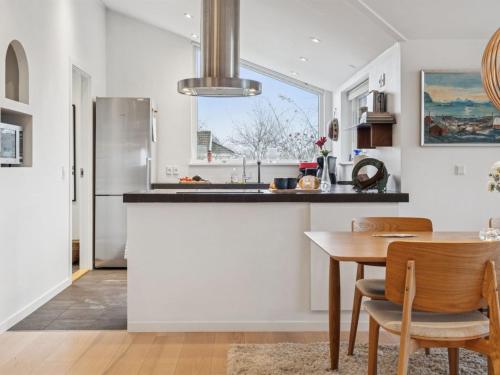 eine Küche mit Tisch und Stühlen und einem Kühlschrank in der Unterkunft Holiday Home Siegfried - 300m to the fjord by Interhome in Kirke-Hyllinge