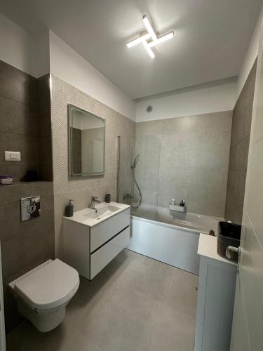 a bathroom with a toilet and a sink and a tub at Lake On Exclusive in Mamaia