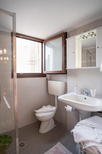 a bathroom with a toilet and a sink and a mirror at Ariadni Luxury Apartment in Samos