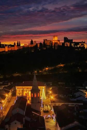 a city lit up at night with a building at Hotel República Boutique Hotel in Tomar