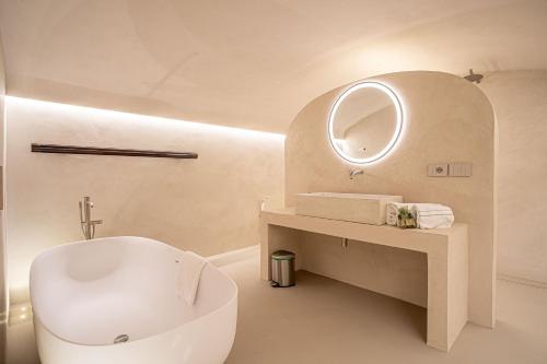 een badkamer met een bad, een wastafel en een spiegel bij Prestigioso Palazzo Fiorentino in Florence