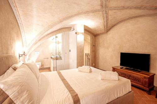 een slaapkamer met een groot bed en een flatscreen-tv bij Prestigioso Palazzo Fiorentino in Florence