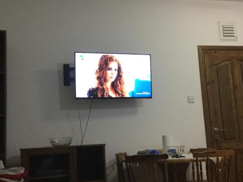 a flat screen tv hanging on a wall at Aphrodite Beachfront Apartment in Ghaziveran