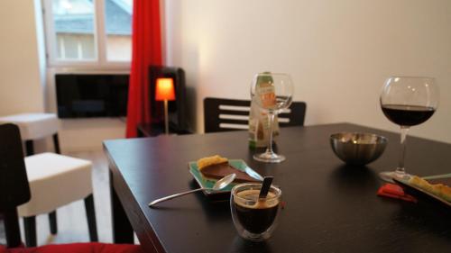 a table with two glasses of wine and a plate of food at Le Vinéa in Beaune