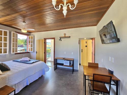 een slaapkamer met een bed en een houten plafond bij Vila Bella Suítes - Conforto no Centro in Carrancas