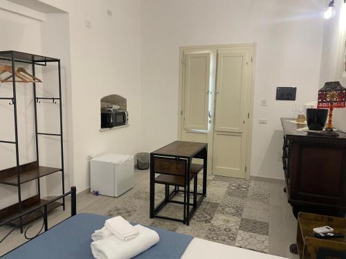 een kamer met een tafel, een stoel en een bureau bij Luxar Suites & Apartments in Assemini