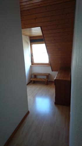Cette chambre mansardée dispose de parquet et d'une fenêtre. dans l'établissement GMA Apartment R11, à Schwanau
