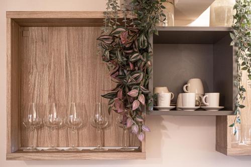 ein Holzschrank mit Weingläsern und einem Blumenkranz in der Unterkunft Romantica Suite nel cuore Firenze in Florenz
