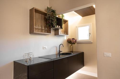 eine Küche mit einer schwarzen Theke und einem Waschbecken in der Unterkunft Romantica Suite nel cuore Firenze in Florenz