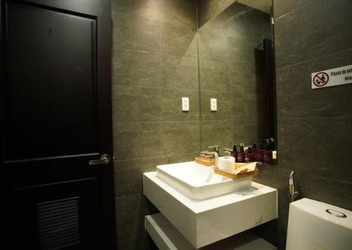 een badkamer met een wastafel en een spiegel en een toilet bij Annam Saigon Home in Ho Chi Minh-stad