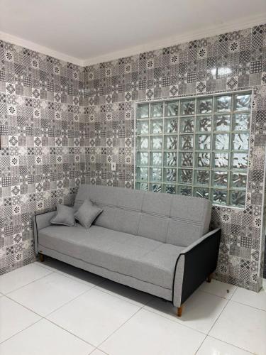 een bank in een kamer met een muur bij Casa Cacau in Ubatuba