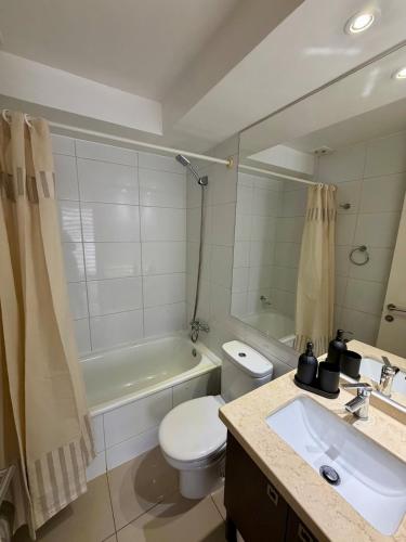 een badkamer met een wastafel, een toilet en een bad bij Sky Park Elite in Santiago