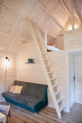 a living room with a couch and a loft bed at Lesne Runo Borsk, basen z podgrzewaną wodą in Borsk