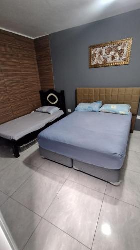 a bedroom with two beds and a picture on the wall at Cintra Home Araçariguama - Casa 04 in Araçariguama