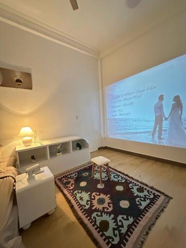 een kamer met een groot scherm waarop een bruidspaar te zien is bij HuếDuo Homestay in Thôn Trường Giang
