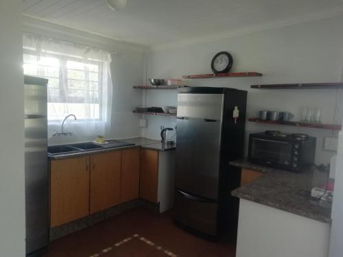 een keuken met een koelkast en een wastafel bij PauMar Guesthouse in Sutherland