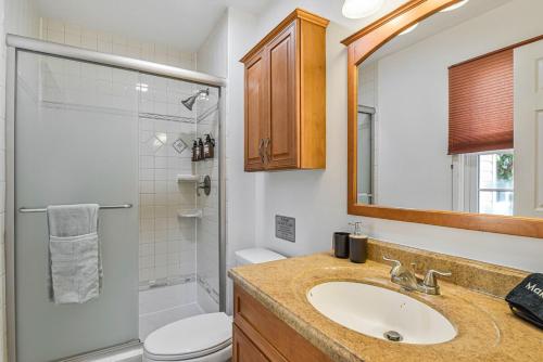 een badkamer met een wastafel, een toilet en een douche bij Cozy 4BR Retreat - Private backyard, Gazebo & Grill in Fairfax