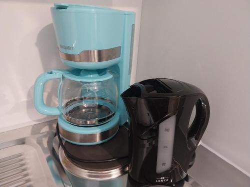 uma máquina de café azul sentada em cima de um balcão em Flora Comfort Inn em Oberhausen