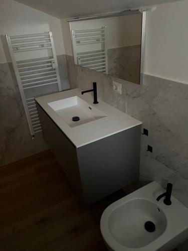 ein Badezimmer mit einem weißen Waschbecken und einem Spiegel in der Unterkunft Airone1 in Gallarate
