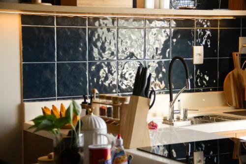 een keuken met een wastafel en een zwart betegelde muur bij Ap Da Ilha in Alter do Chao