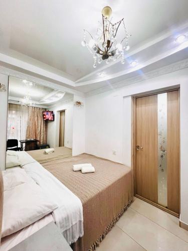 a large bedroom with a large bed and a chandelier at CityCenter Studio in Chişinău
