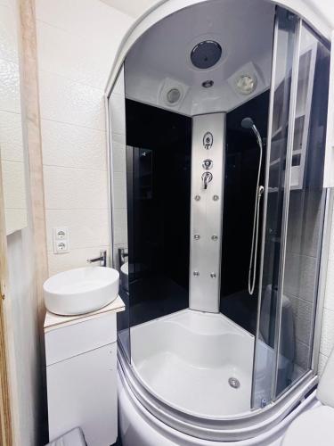 a bathroom with a shower and a toilet and a sink at CityCenter Studio in Chişinău