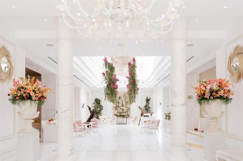 a large white hallway with flowers in vases at Boscolo Nice Hotel & Spa in Nice