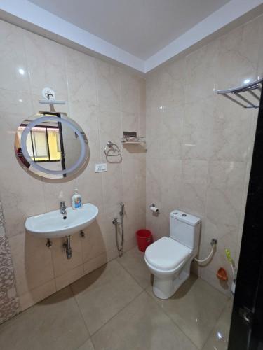 a bathroom with a toilet and a sink and a mirror at Square Greens in Siolim