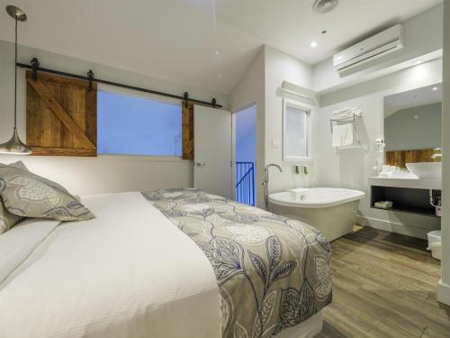 une chambre avec un lit, une baignoire et un lavabo dans l'établissement Hotel Lac Brome, BW Signature Collection, à Lac-Brome