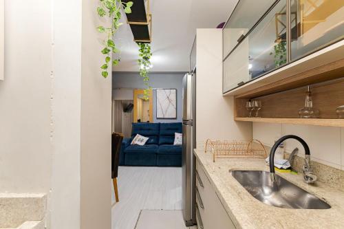 eine Küche mit einem Waschbecken und einem blauen Sofa in der Unterkunft Edifício La Tour Residence | Centro – Curitiba in Curitiba