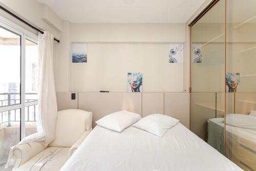 ein Schlafzimmer mit einem weißen Bett und einem Fenster in der Unterkunft Edifício La Tour Residence | Centro – Curitiba in Curitiba