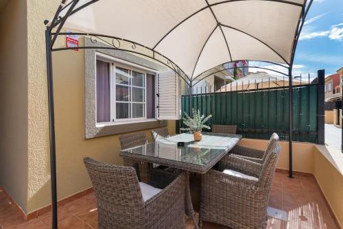 eine Terrasse mit Tisch und Stühlen auf einem Balkon in der Unterkunft Bungalow - Playa Maspalomas in San Bartolomé de Tirajana