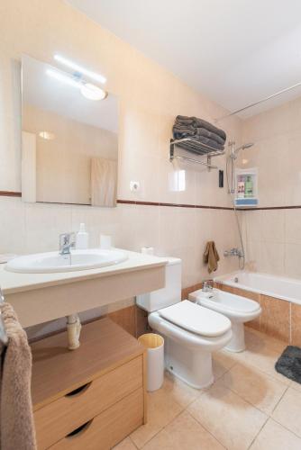 a bathroom with a sink and a toilet and a tub at Bungalow - Playa Maspalomas in San Bartolomé