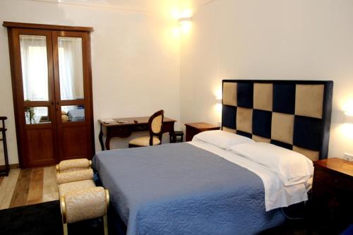 ein Schlafzimmer mit einem Bett, einem Schreibtisch und einem Tisch in der Unterkunft Pompei suite via roma 16 in Pompei