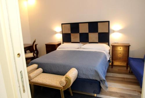 ein Schlafzimmer mit einem großen Bett und einem Stuhl in der Unterkunft Pompei suite via roma 16 in Pompei