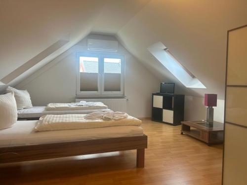 a attic bedroom with two beds and a window at "Villa Harmonie" direkt am Golfplatz in Göhren-Lebbin