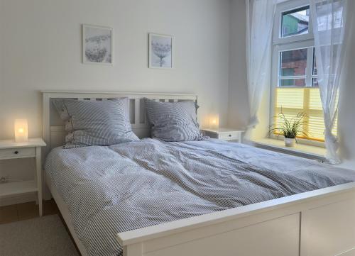 een witte slaapkamer met een groot bed en een raam bij Ferienwohnung Medemspeicher in Otterndorf