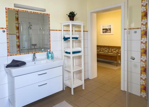 een badkamer met een wastafel en een spiegel bij Ferienwohnung Medemspeicher in Otterndorf