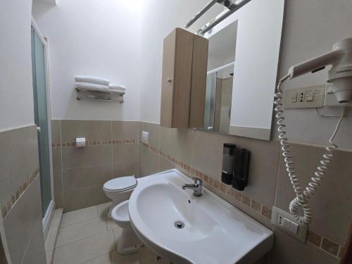 a bathroom with a sink and a toilet and a mirror at La Dimora Di Pienza in Val d'Orcia in Pienza
